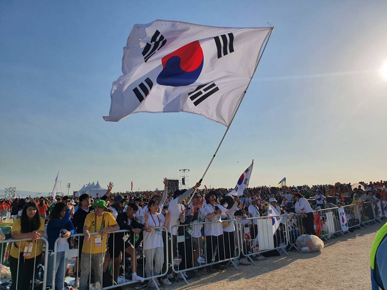 Dél-koreai zarándokok zászlót lengetnek a lisszaboni ifjúsági világtalálkozó Ferenc pápa által bemutatott zárómiséjén, 2023. augusztus 6-án. | Fotó: Hannah Brockhaus/EWTN News